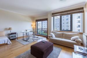 uma sala de estar com um sofá e uma mesa em Deluxe Condominium with Ocean View em Porto