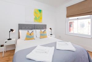 um quarto branco com uma cama grande e 2 toalhas em The Mount Hideaway with Hot Tub em York