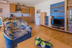a living room with a couch and a table and a tv at Two-Bedroom Apartment in Crikvenica VI in Sopaljska