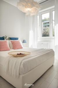 a white bedroom with a large bed with a table on it at Oki Doki Studios in Milan