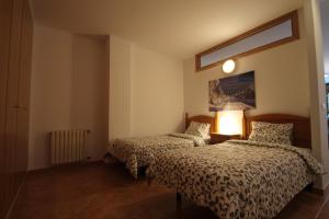 ein Schlafzimmer mit 2 Betten und einer Lampe auf einem Tisch in der Unterkunft Pont de Toneta 1,6 Ransol, Zona Grandvalira in Ransol