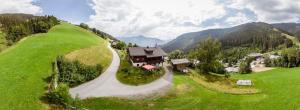 z góry widok na dom na zielonym wzgórzu w obiekcie Appartement Schmiedhof w mieście Zell am See