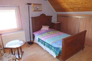 a bedroom with a bed and a lamp and a table at Gîte rustique sous combles in Merxheim