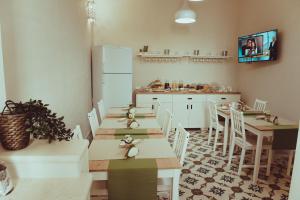 une salle à manger avec tables et chaises et une cuisine dans l'établissement La Dimora di Teti, à Gallipoli