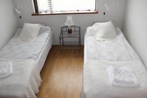 duas camas num quarto com uma mesa e uma janela em Fosstún Guesthouse em Skógar