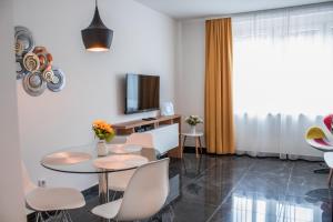 een woonkamer met een tafel en stoelen en een televisie bij Apartment Latin Bridge in Sarajevo