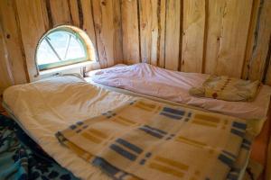 Midgard في Osiecznica: سرير في غرفة خشبية مع نافذة