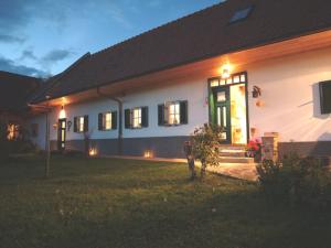 Biały dom z zielonymi drzwiami i oknami w obiekcie Sonnenhaus Grandl w mieście Feldbach