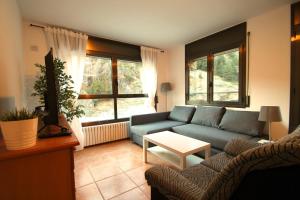 a living room with a blue couch and a table at Pont de Toneta 2,1 Ransol, Zona Grandvalira in Ransol