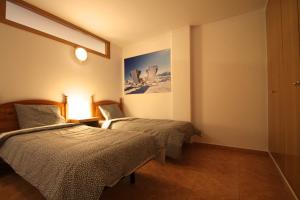 um quarto com duas camas e uma foto na parede em Pont de Toneta 2,1 Ransol, Zona Grandvalira em Ransol