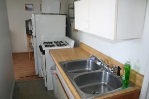 La cuisine est équipée d'un évier et d'un réfrigérateur blanc. dans l'établissement Nautical Beach Properties, à Hampton Beach