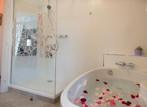 a bathroom with a bath tub with flowers on the floor at Occitanie Aquitaine gîte 5 pers -SPA privé-CLIM- Draps, vélos inclus - Equipé pour bébé in Soturac +65 photos