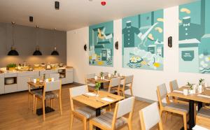a restaurant with wooden tables and chairs and a kitchen at poznańska19 in Nowy Tomyśl
