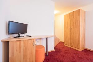 Zimmer mit Schreibtisch und TV in der Unterkunft FINIDA, motel, restavracija in pivovarna in Obrov