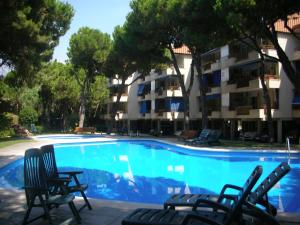 une piscine avec des chaises et un bâtiment dans l'établissement Groc Gava, à Gavà