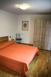 ブレンゾーネにあるCa di Venzoのベッドルーム(大きなオレンジ色のベッド1台、椅子付)
