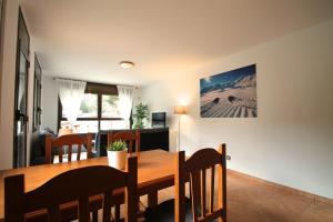 a dining room and kitchen with a wooden table and chairs at Pont de Toneta 2,6 Ransol, Zona Grandvalira in Ransol