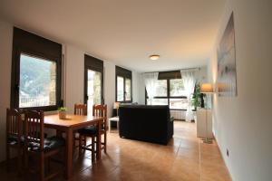 a dining room with a table and chairs and a living room at Pont de Toneta 2,6 Ransol, Zona Grandvalira in Ransol