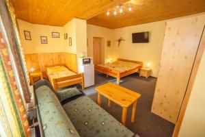 a room with two beds and a kitchen with a couch at Penzion Na Rozcestí in Janov nad Nisou