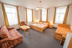 - un salon avec un lit, des chaises et des fenêtres dans l'établissement Penzion Na Rozcestí, à Janov nad Nisou