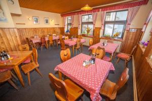 a restaurant with tables and chairs with pink tables at Penzion Na Rozcestí in Janov nad Nisou