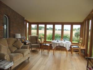 ein Wohnzimmer mit einem Sofa und einem Tisch in der Unterkunft St Mary’s Lodge B and B in Kings Lynn