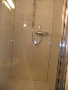 a shower stall with a glass door with a shower at St Mary’s Lodge B and B in Kings Lynn