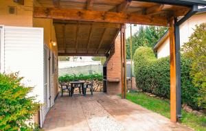 un patio con mesa y sillas bajo una pérgola de madera en Cabañas Don Mario, en Sierra de la Ventana