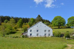 an old white barn in a field of grass at viaux-fontaine in Saulxures-sur-Moselotte