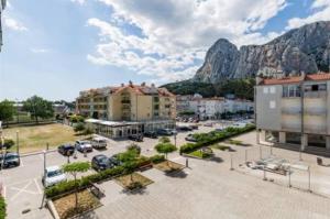 eine Stadt mit einem Parkplatz mit Bergen im Hintergrund in der Unterkunft Granny Mira in Omiš