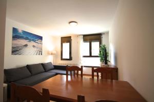ein Wohnzimmer mit einem Sofa und einem Tisch in der Unterkunft Pont de Toneta 3,2 Ransol, Zona Grandvalira in Ransol