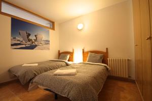 two twin beds in a room with avertisement for at Pont de Toneta 3,3 Ransol, Zona Grandvalira in Ransol