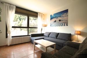 a living room with a blue couch and a table at Pont de Toneta 3,3 Ransol, Zona Grandvalira in Ransol