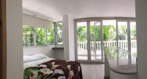 a bedroom with a bed and a balcony with windows at Casona La Carolina in San Andrés