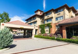 un bâtiment d'hôtel avec un parking en face de celui-ci dans l'établissement Hotel Kelowna & Conference Centre, à Kelowna