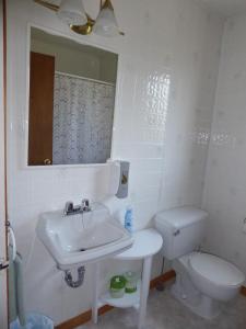 y baño con lavabo, aseo y espejo. en Hébergement Maison Fortier, en Tadoussac