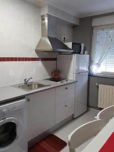 ベガデオにあるApartamento Ria del Eoの白いキッチン(シンク、冷蔵庫付)