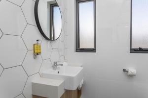 a bathroom with a sink and a mirror at Civic Apartments in Wagga Wagga