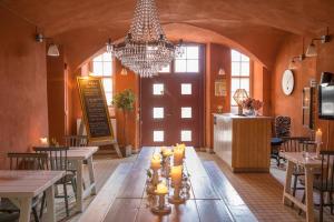 a dining room with tables and a chandelier at Kastellet Bed & Breakfast in Vaxholm
