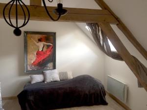 a bedroom with a bed and a painting on the wall at Kasaloc in Maintenon
