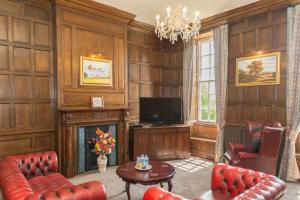 a living room with a fireplace and a television at Haughton Hall in Telford