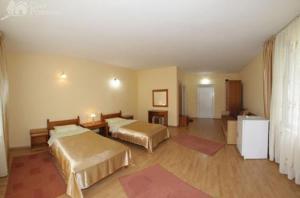 バイア・スプリエにあるPensiunea Limpedeaのベッド2台とテーブルが備わるホテルルームです。
