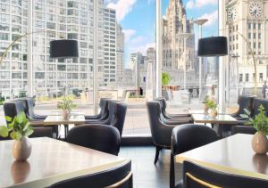 シカゴにあるトランプ インターナショナル ホテル & タワー シカゴのテーブルと椅子、大きな窓のあるレストラン