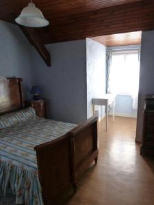 1 dormitorio con cama, mesa y ventana en Chambres d'Hôtes La Plantade en La Barthe-de-Neste
