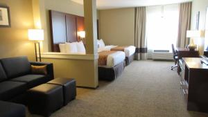 a hotel room with two beds and a couch at Comfort Inn & Suites Boise Airport in Boise