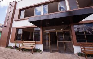 a building with two benches outside of it at Hotel Holliday in Macapá