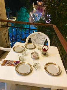 uma mesa branca com pratos e copos numa varanda em Fountain Square-Balconies in Old Town em Baku