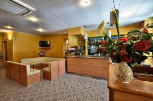 a waiting room with a counter and a vase of flowers at Hotel Guya in Varazze
