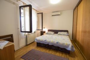 a small bedroom with a bed and a window at Apartments Elza in Opric