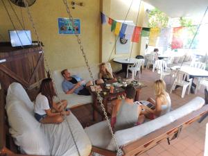 a group of people sitting on a porch swing at Reef Lodge Backpackers in Townsville